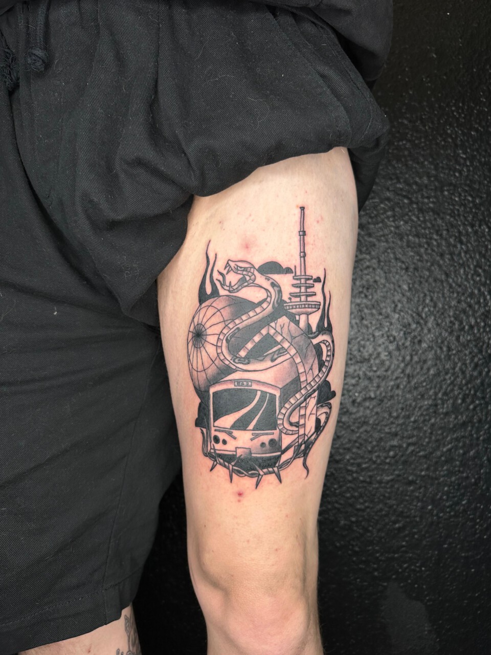 Traditional Tattoo Schlange mit U-Bahn, Fernsehturm und Globus am Oberschenkel — Kenneth, Blank Tattoo Hildesheim