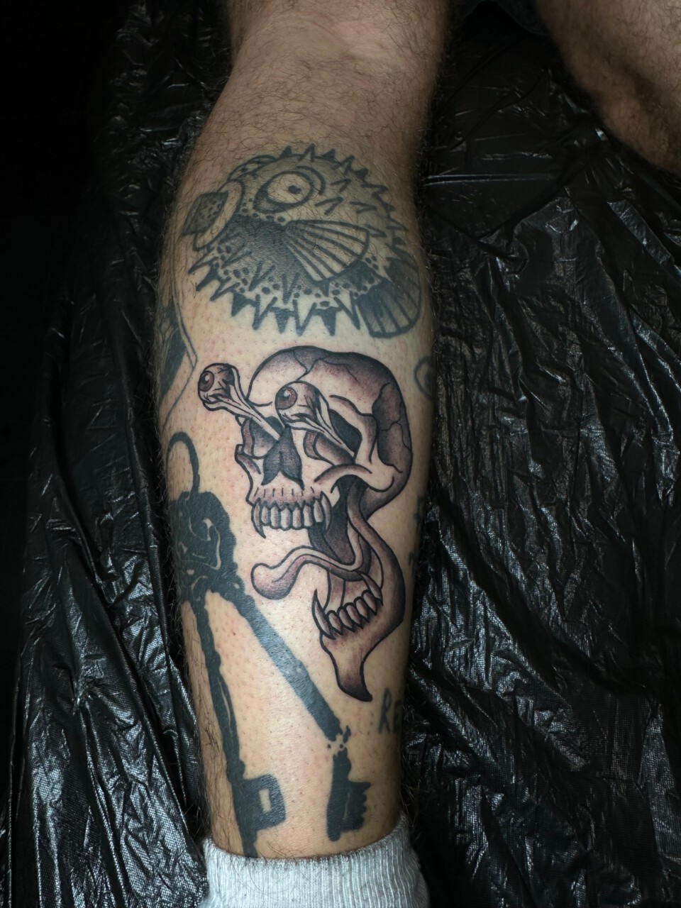 Traditional Tattoo Totenkopf mit Kugelfisch am Unterschenkel — Kenneth, Blank Tattoo Hildesheim