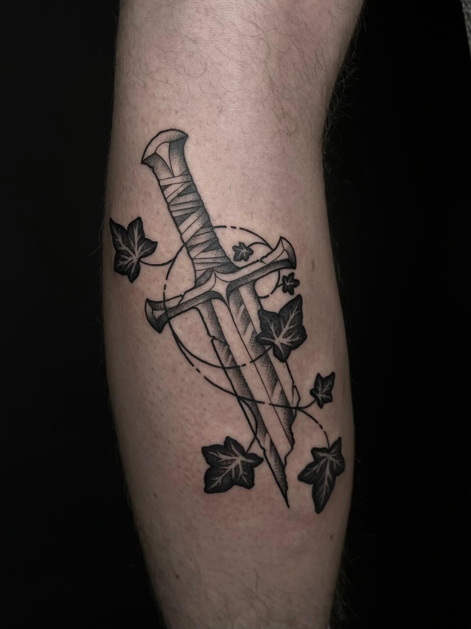 Neotraditional Tattoo zerbrochenes Schwert mit Efeuranken am Unterschenkel — Mel, Blank Tattoo Hildesheim